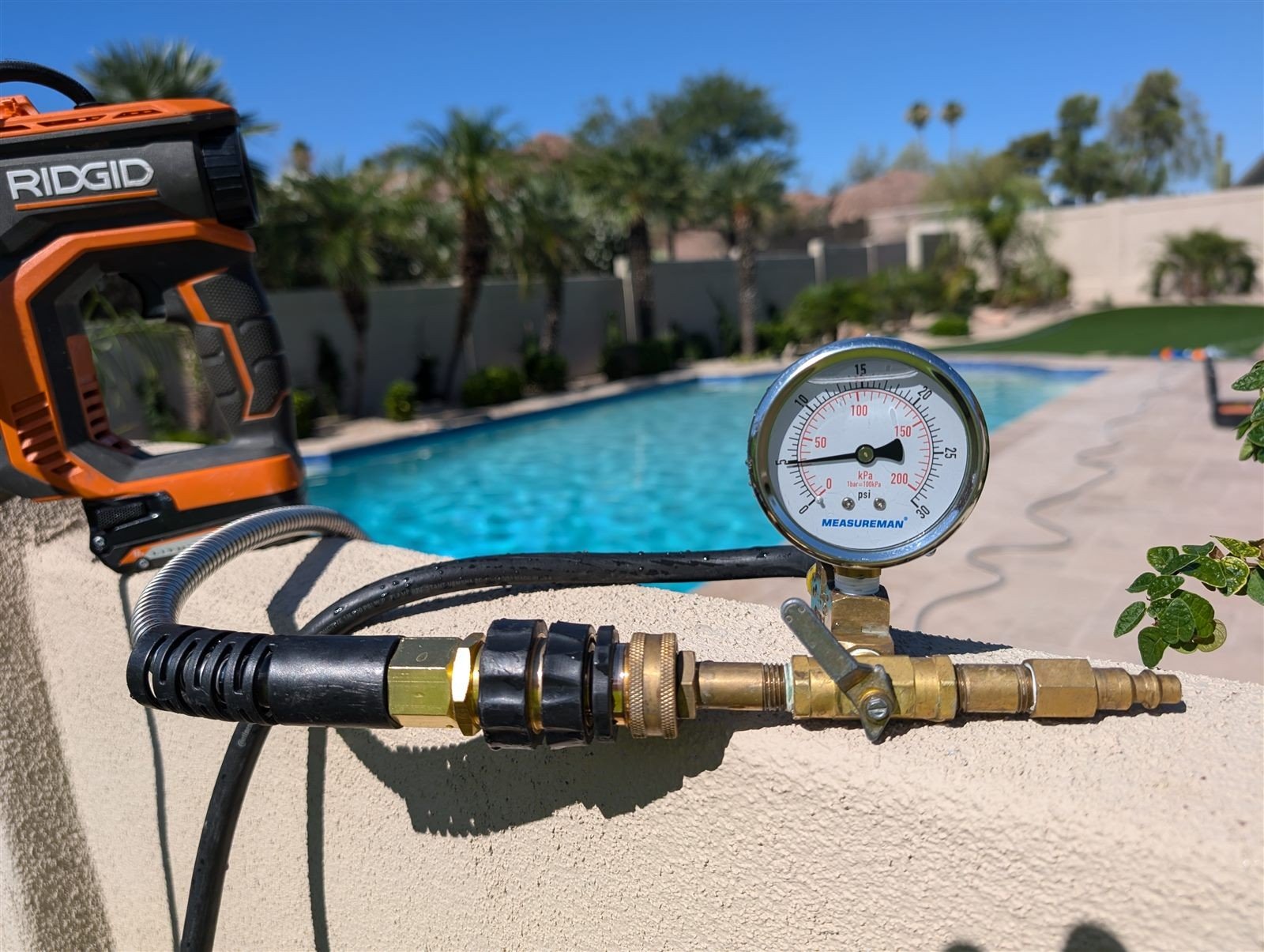 Pressure gauge rig on a pool line during a leak test in Cathedral City