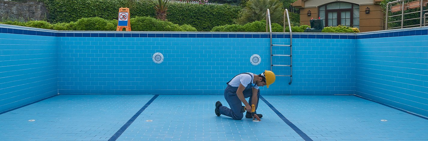 Worker repairing the floor of an empty pool in Cathedral City