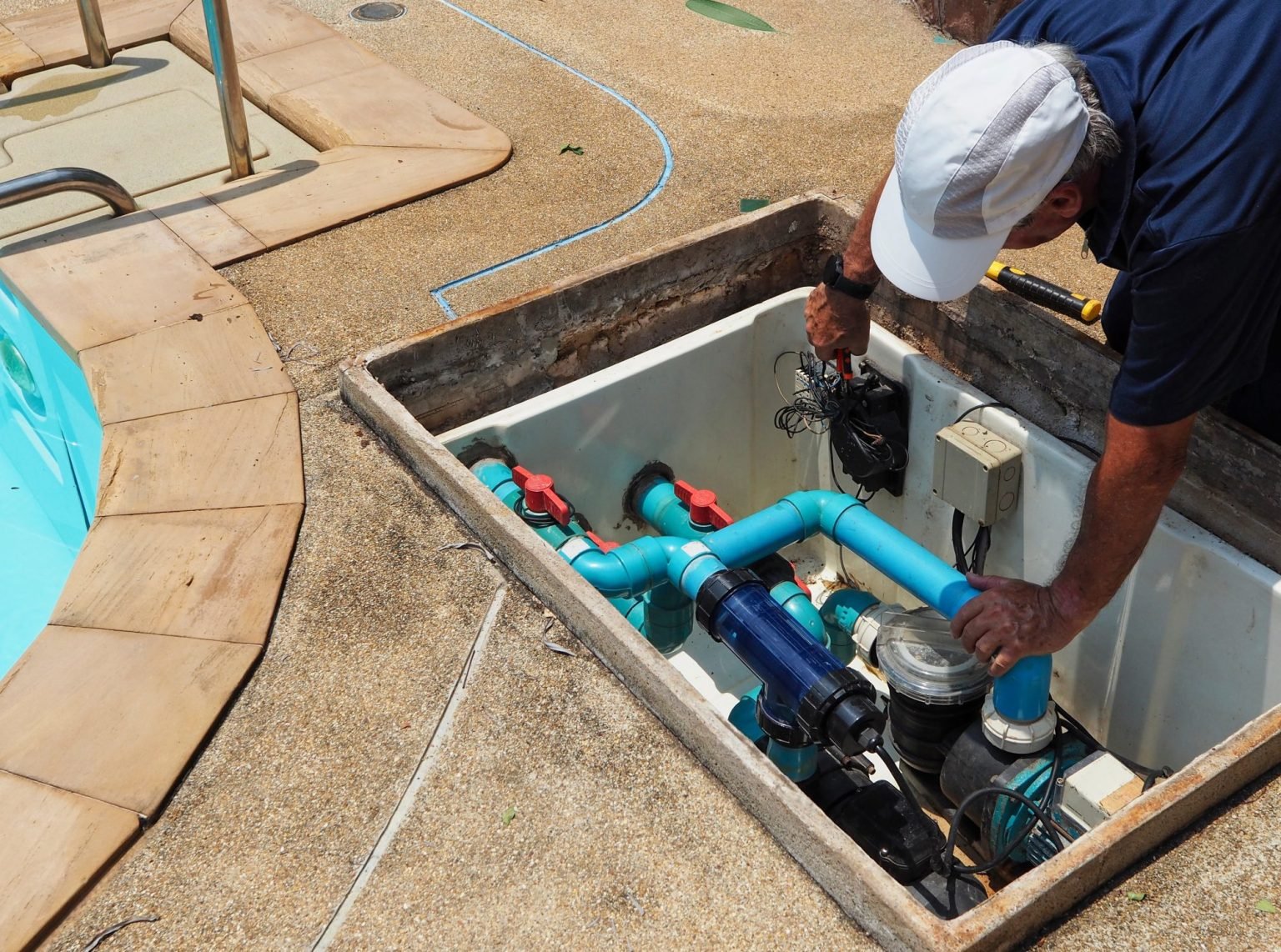 Pool tech checking pump and pipe gear during a leak visit in Cathedral City