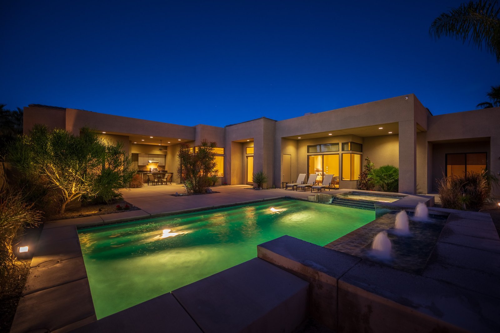 Desert home pool and spa glowing at dusk in Cathedral City