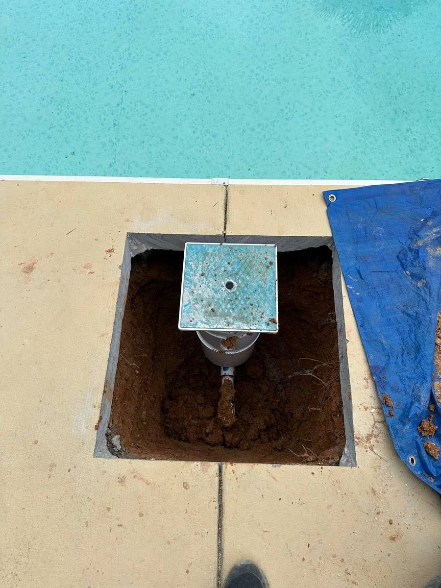 Small square opening in a pool deck showing the buried pipe found in Cathedral City